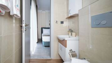 Un baño moderno con lavabo, espejo y perchero para toallas.