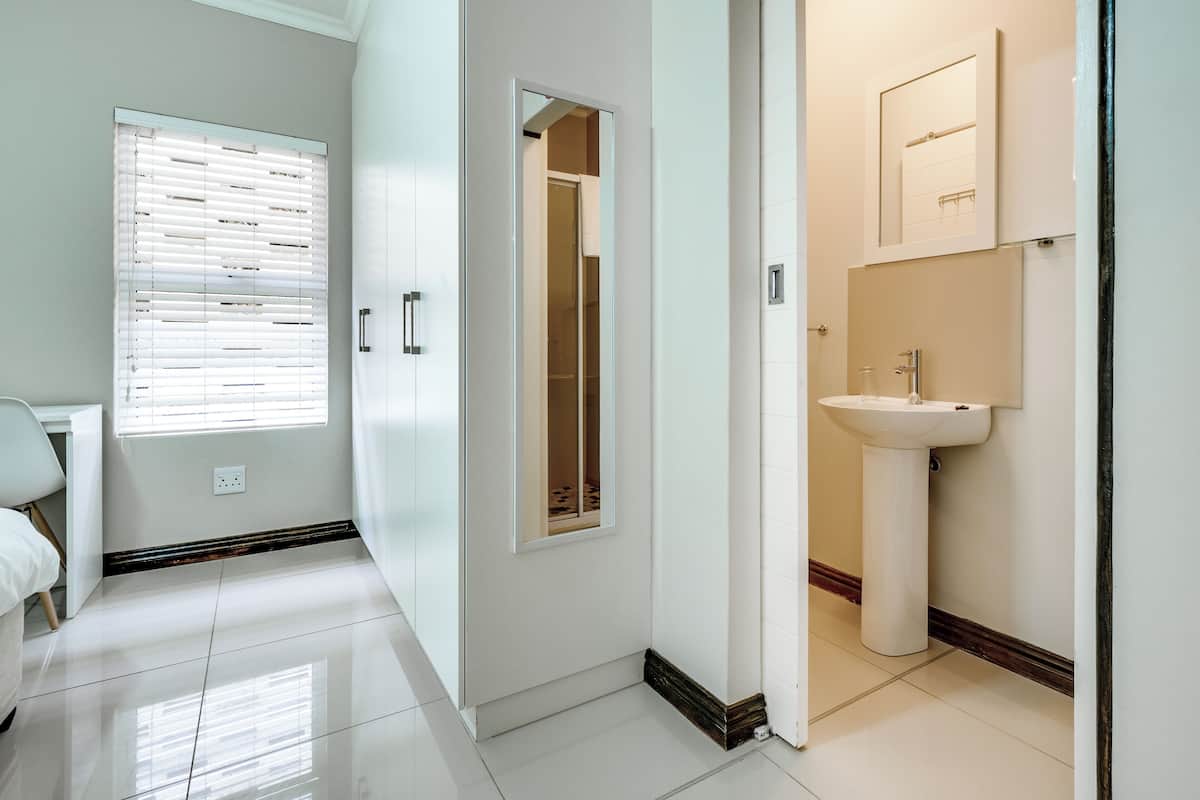 A modern bathroom with a sink, mirror, and cabinet.