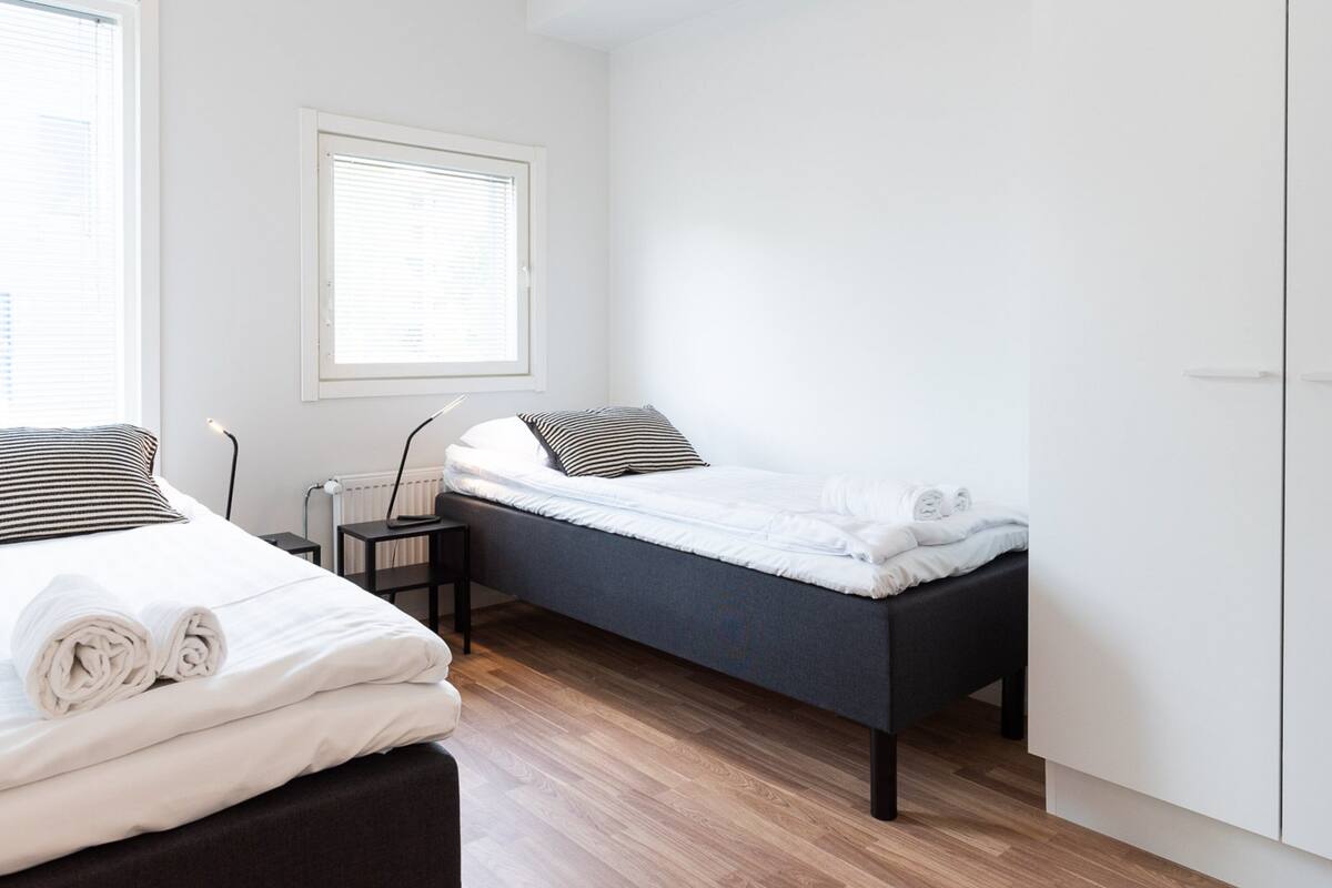 A modern bedroom with a bed, a bench, and a wardrobe.