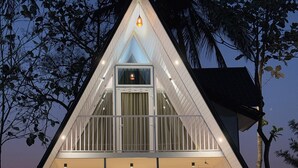 A modern, triangular-shaped building with a balcony and large windows. - Cosmic Connect Trails Kabini (Heggadadevankote)