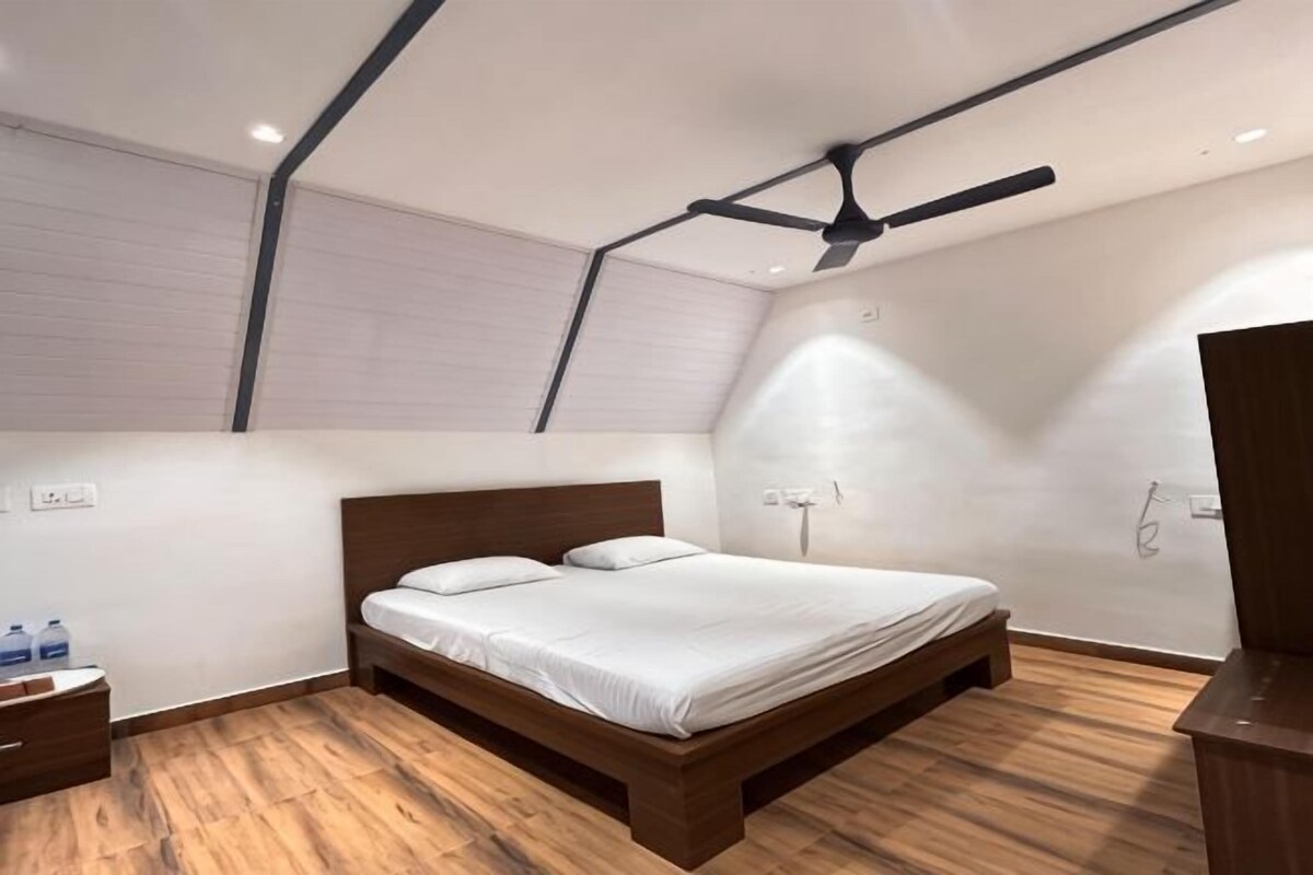 A bedroom with a wooden bed, a ceiling fan, and a wooden floor.
