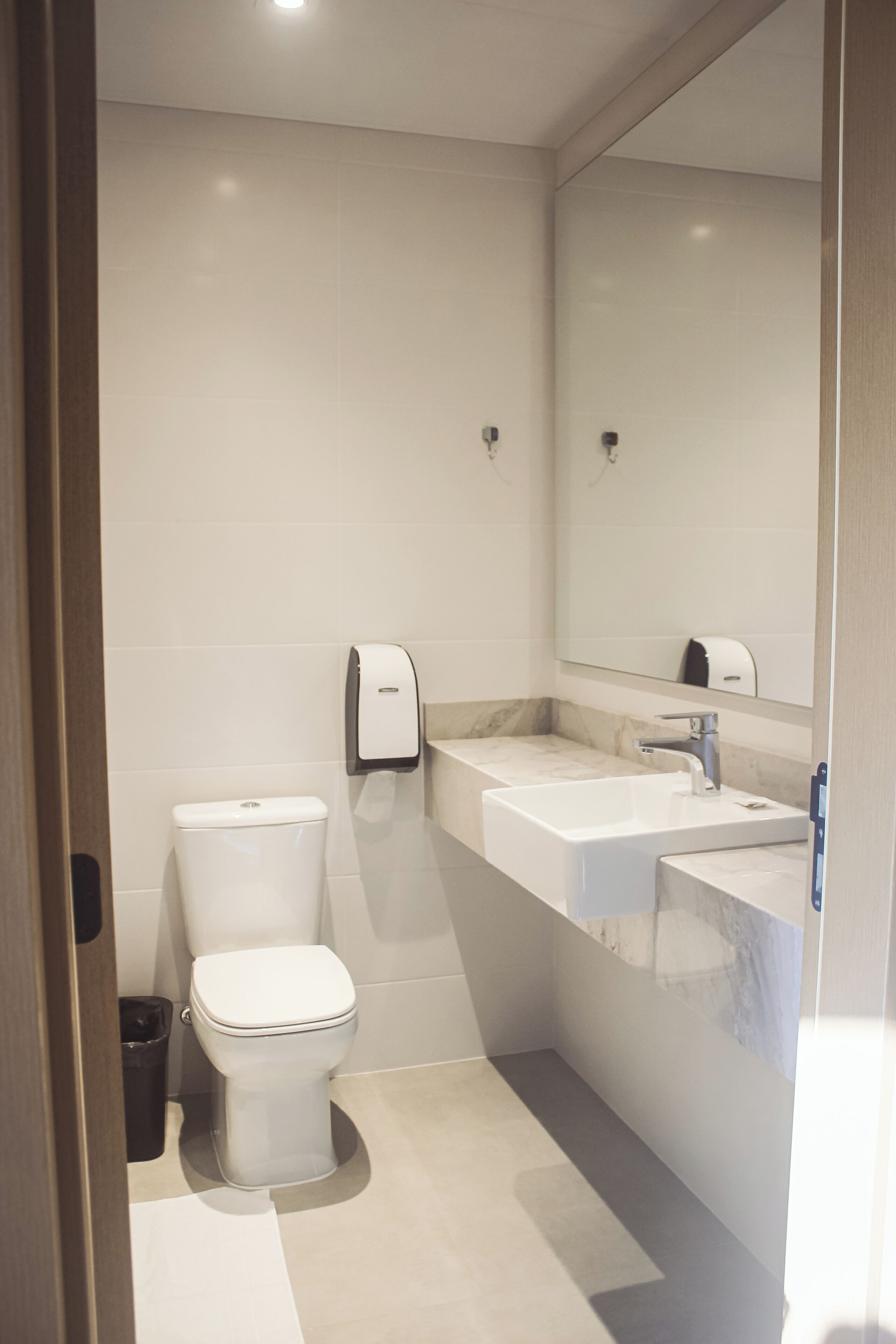 Une salle de bain moderne avec des toilettes, un lavabo et un miroir.
