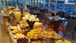 Una mesa de buffet con diversos alimentos y una ventana grande al fondo.