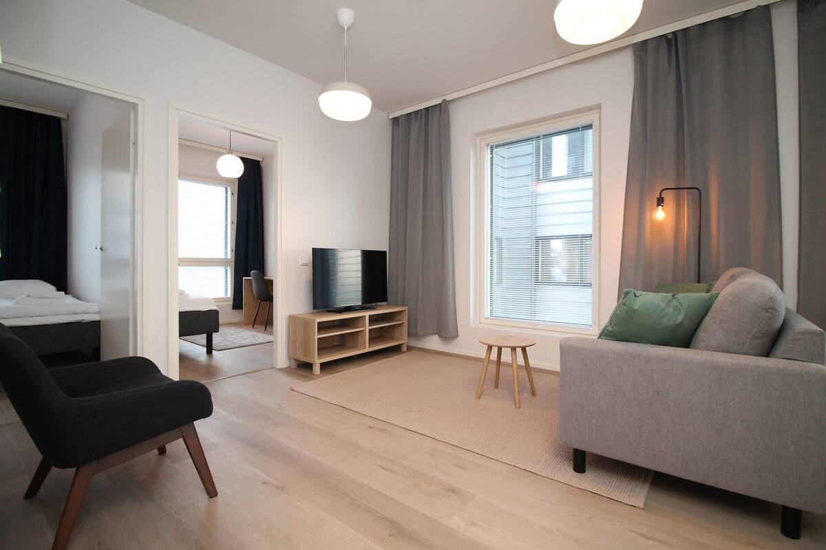 Ein modernes Wohnzimmer mit einer Couch, einem Fernseher und einer Holz-Multimöbelanlage.