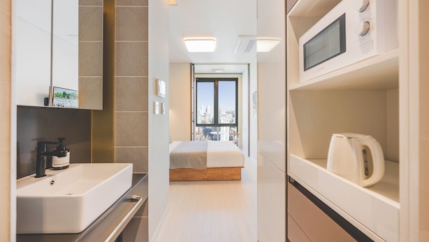 A modern hotel room with a large bed, a built-in sink, and a microwave. - Gemstay Seomyeon (Busan)