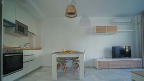 Une cuisine moderne équipée d’un four à micro-ondes, d’un four traditionnel et d’une table à manger avec des chaises.