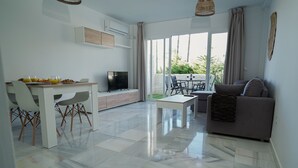 Un salon moderne comprenant un coin repas, un téléviseur à écran plat et un balcon avec vue.