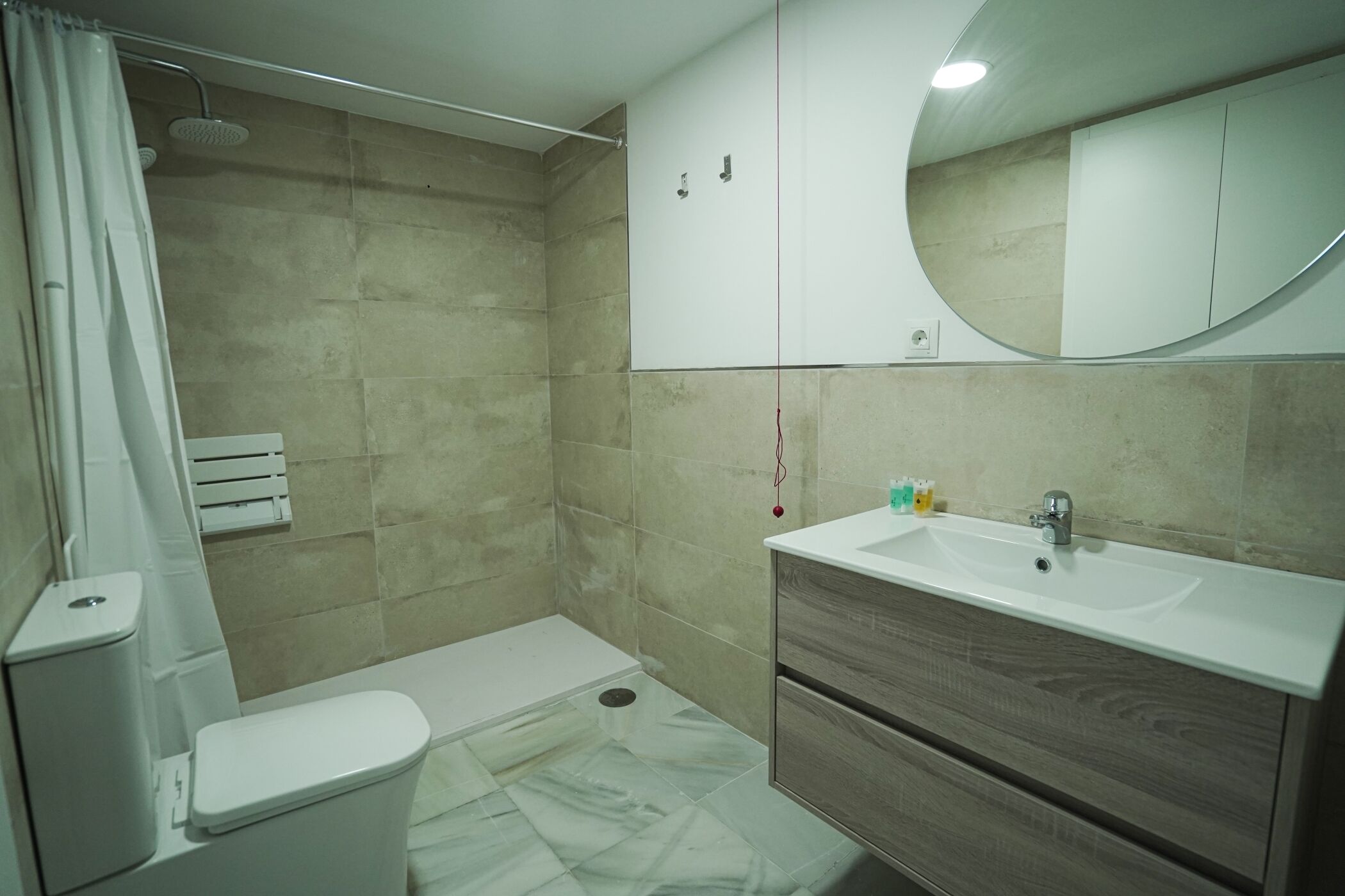 Un bagno moderno con doccia, WC, lavandino e mobile lavabo.