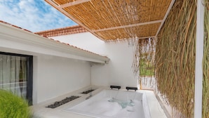 A modern outdoor spa area with a hot tub, a bamboo ceiling, and a white wall. - Ajlan Beach (Ayvalik)