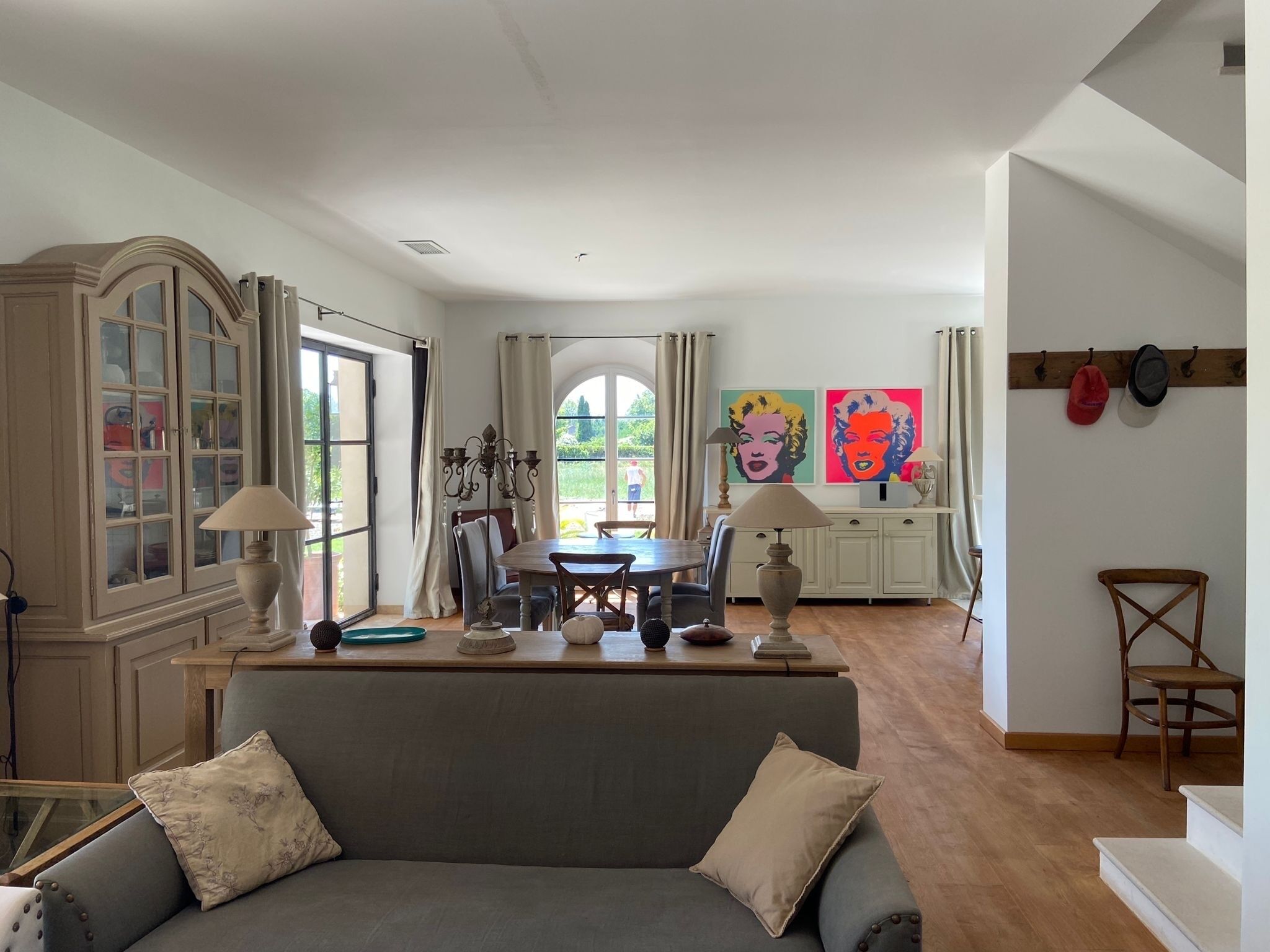 A spacious living area with a dining table, a sofa, and a cabinet.