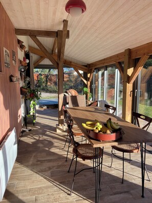 A wooden dining area with a table set for four, surrounded by chairs.