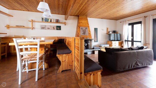 A cozy living room with a wooden dining table, a sofa, and a fireplace. - Italianway - Capitano Grandi 5 (Bormio)