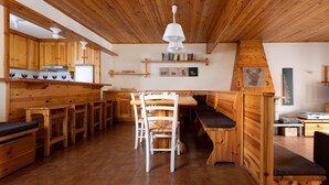 A wooden interior with a kitchen, dining area, and seating. - Italianway - Capitano Grandi 5 (Bormio)