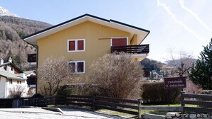 Ein gelbes Gebäude mit roten Fensterläden und einem Balkon, mit einem Schild, auf dem "residenza S. Sebastiano" steht.
