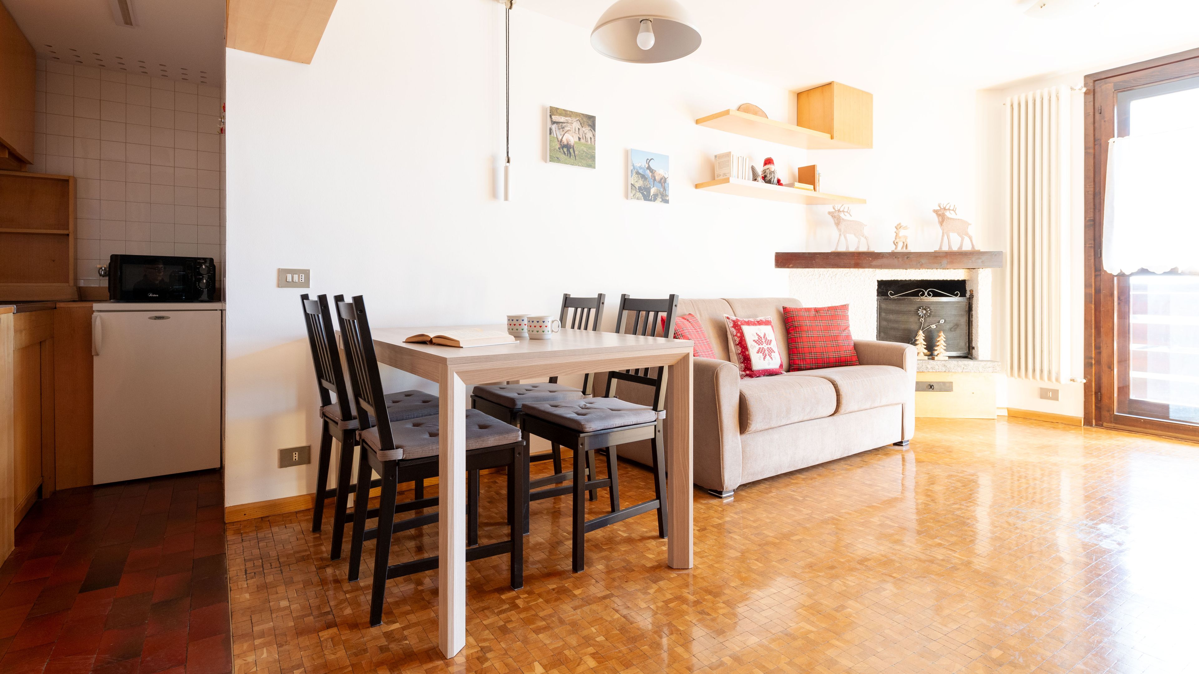Een moderne woonkamer met een eettafel, stoelen, een bank en een open haard.