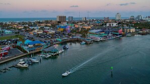 Un puerto deportivo con barcos amarrados, una noria y edificios a lo largo del paseo marítimo.