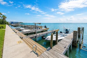 Un port de plaisance avec des quais en bois, des bateaux et un ciel d’un bleu limpide.