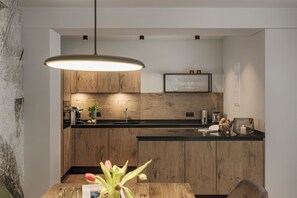 Enjoy cooking in this kitchen with a central island, pendant light, and wooden cabinetry.