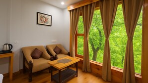 Una habitación acogedora con dos sofás, una mesa de centro de madera y una ventana con cortinas.