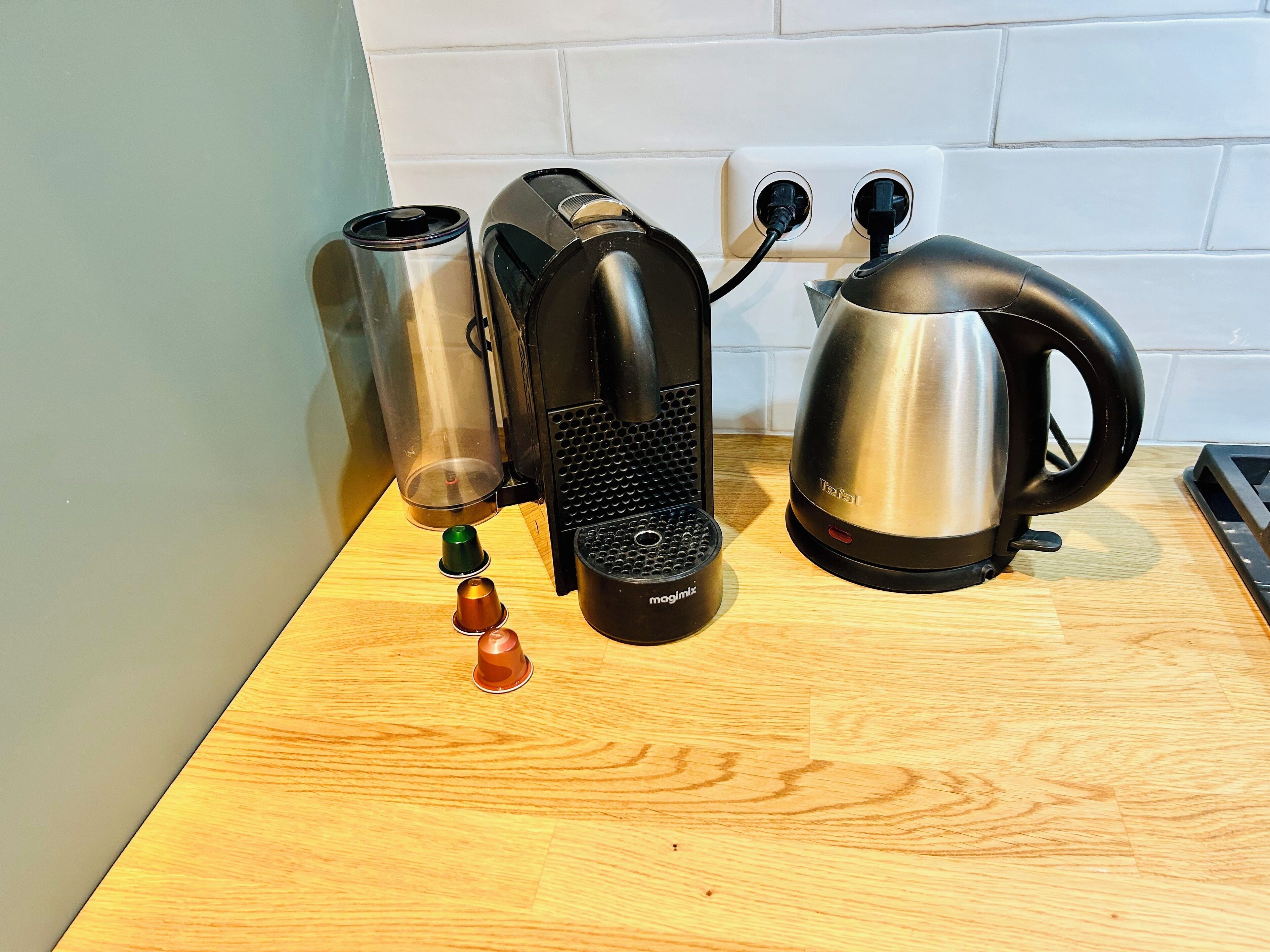 Eine Küchenarbeitsplatte mit Kaffeemaschine, Wasserkocher und Thermoskanne.