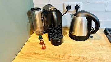 Eine Küchenarbeitsplatte mit Kaffeemaschine, Wasserkocher und Thermoskanne.
