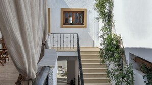 A white building with a staircase leading to a window. - Eva Studios & Apartments (Malevizi)