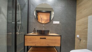Une salle de bain moderne avec une douche à parois de verre, un meuble-lavabo en bois et des toilettes.