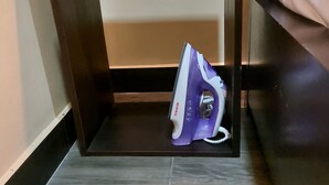 Una mesa de madera pequeña y vacía de color oscuro con un hierro morado encima.