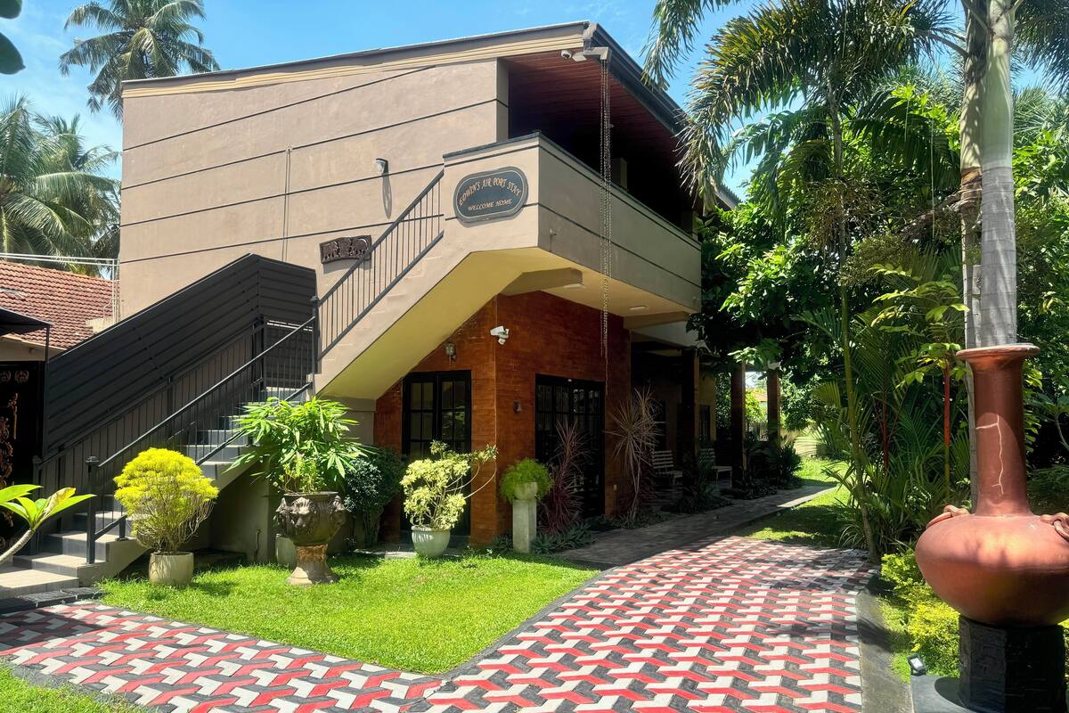 Un edificio de dos pisos con un letrero que dice "GODWIN'S AIR PORT SUITE" y una escalera que lleva a la entrada.