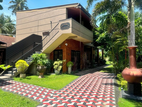 Un edificio de dos pisos con un letrero que dice "GODWIN'S AIR PORT SUITE" y una escalera que lleva a la entrada.