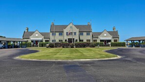 Ein großes, zweistöckiges Gebäude mit einer symmetrischen Fassade, einem zentralen Eingang und einer Fahnenstange mit der US-amerikanischen Flagge.