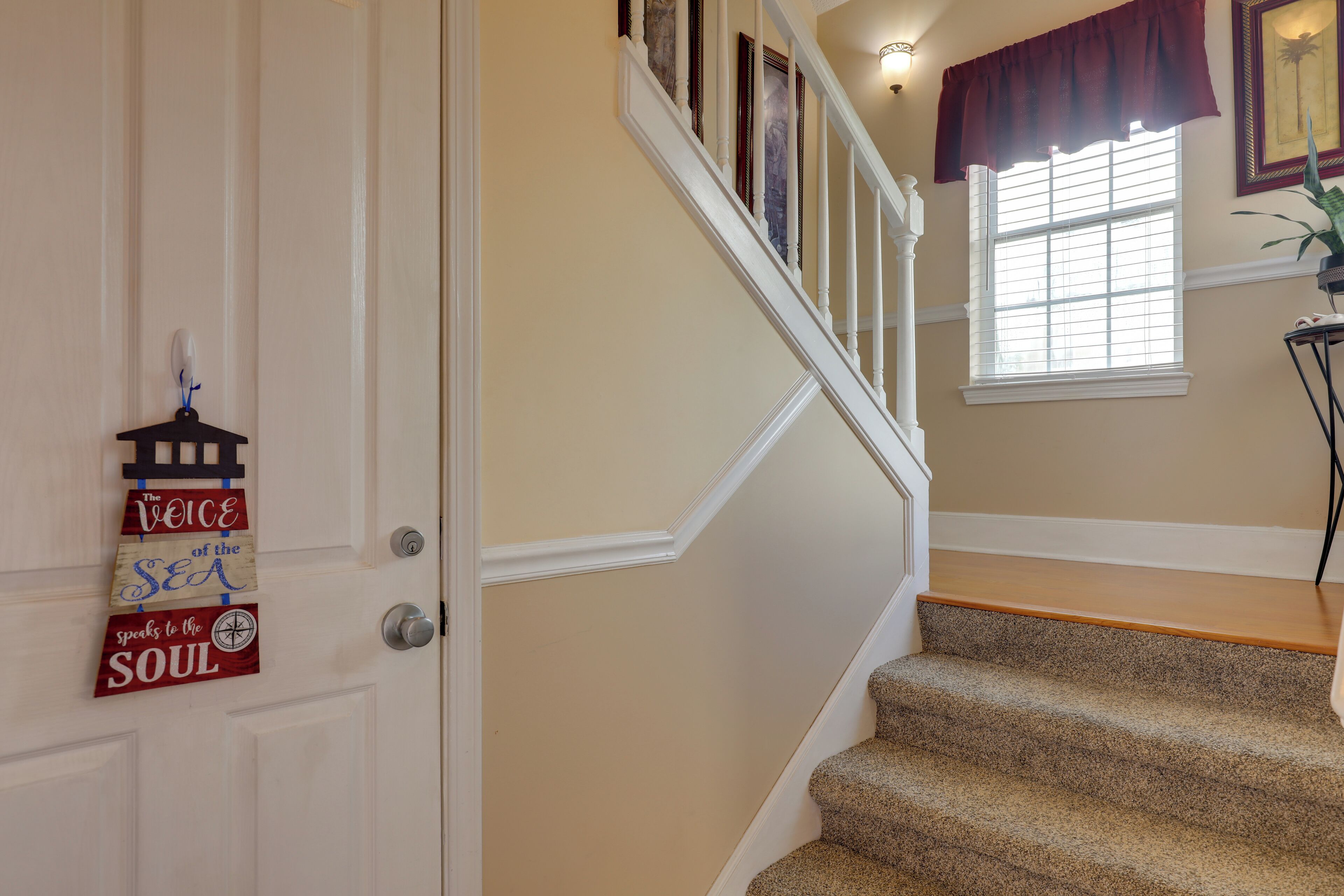 A staircase with beige walls and a wooden handrail.