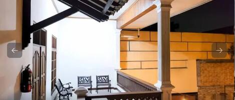 A staircase with a wooden railing, a fire extinguisher, and two chairs.