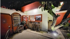 A small outdoor seating area with a bicycle, a table, and a chair.