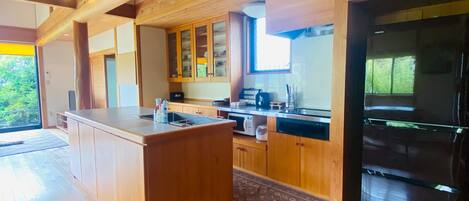 A modern kitchen with wooden cabinets, a central island, and a built-in refrigerator.