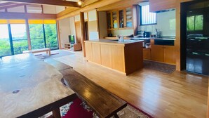 Une cuisine spacieuse dotée de meubles en bois, d’un îlot central et d’une grande fenêtre offrant une vue sur l’extérieur.