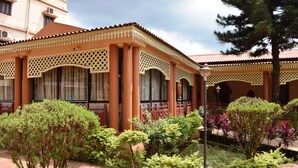 A building with a tiled roof, large windows, and a garden with various plants. - Empires Joda  (Barbil)