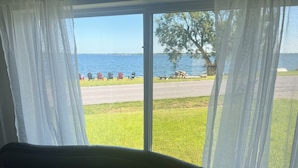 A room with a view of a lake, outdoor seating, and a grassy area. - Lake Ontario getaway 30 mins from Alexandria Bay and the famous Bolt Castle. (Dexter)