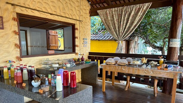 Un espace buffet proposant une variété de plats et de boissons, une table en bois et un comptoir où sont servis les boissons.