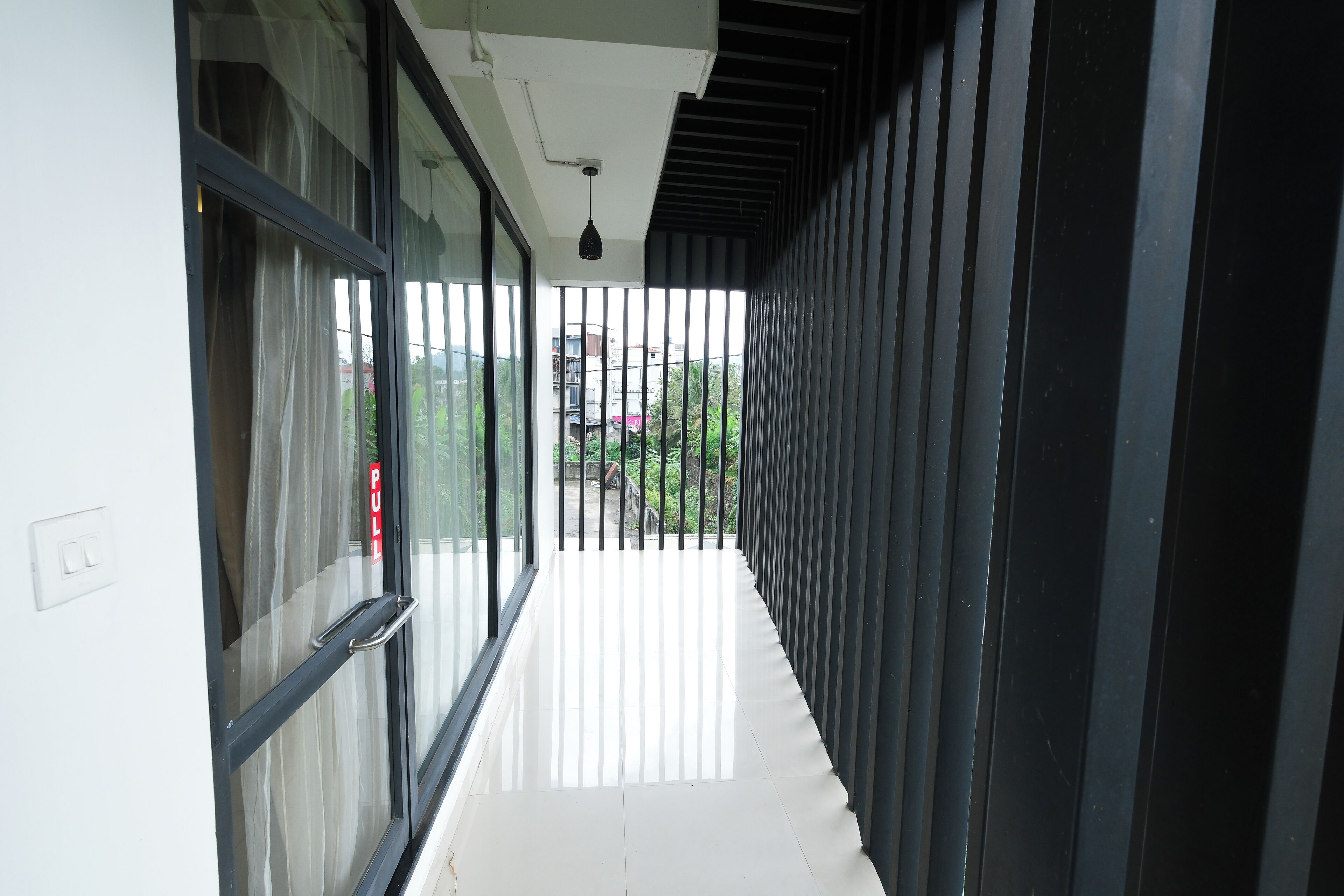 A corridor with glass doors, a pull handle, and a ceiling light fixture.