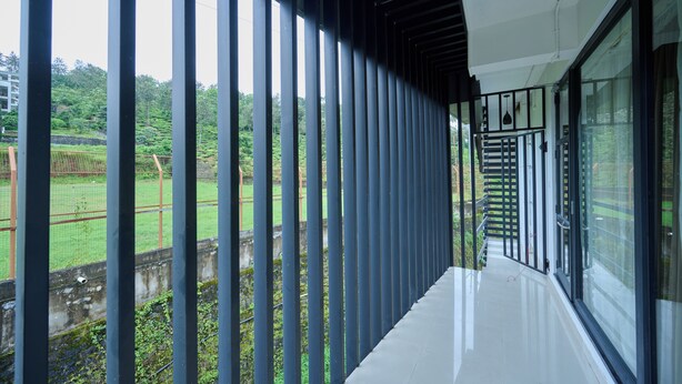 Un pasillo con vistas a un paisaje verde, una escalera y una barandilla.