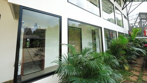 Un edificio moderno con ventanas amplias y un espacio exterior cubierto con plantas.