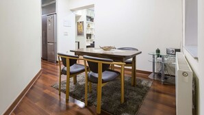 Une cuisine de taille réduite comprenant une table à manger, des chaises et un réfrigérateur.