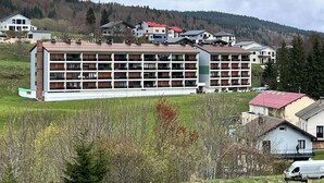 A multi-story hotel with a central courtyard, surrounded by a hilly landscape. - Mountain apartment with a beautiful view on the village of Les Rousses (Les Rousses)