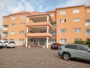 A multi-story building with a flat roof, balconies, and a covered entrance. - Embassy royal. Kick back and relax at this modern Spacious family friendly  home (Kingston)