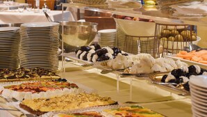 Une table de buffet garnie de divers plats et agrémentée d’une grande plante décorative.