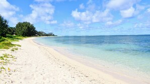 A beach with clear water and a sandy shore.