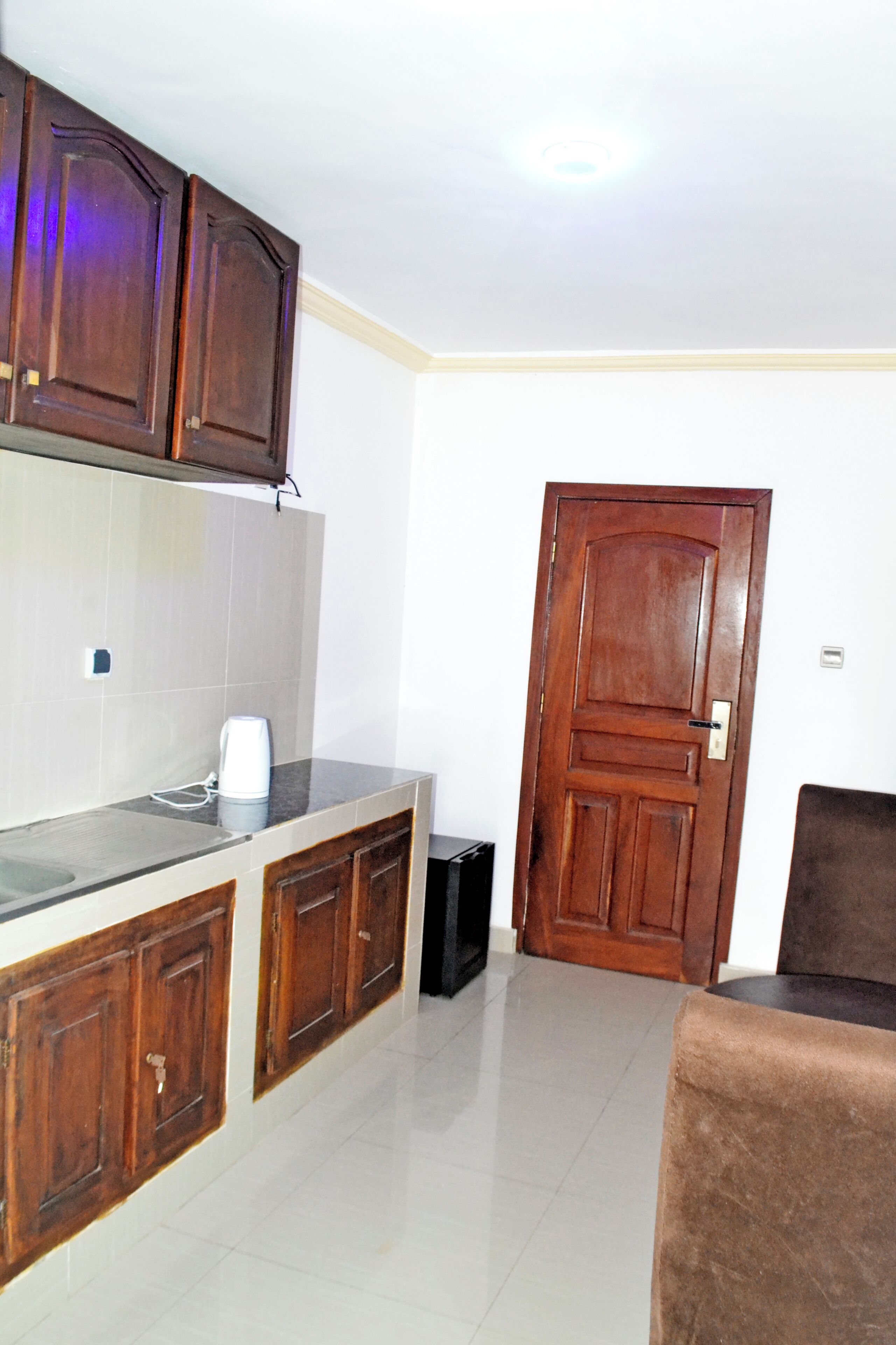 A kitchen with wooden cabinets, a countertop, and a door.