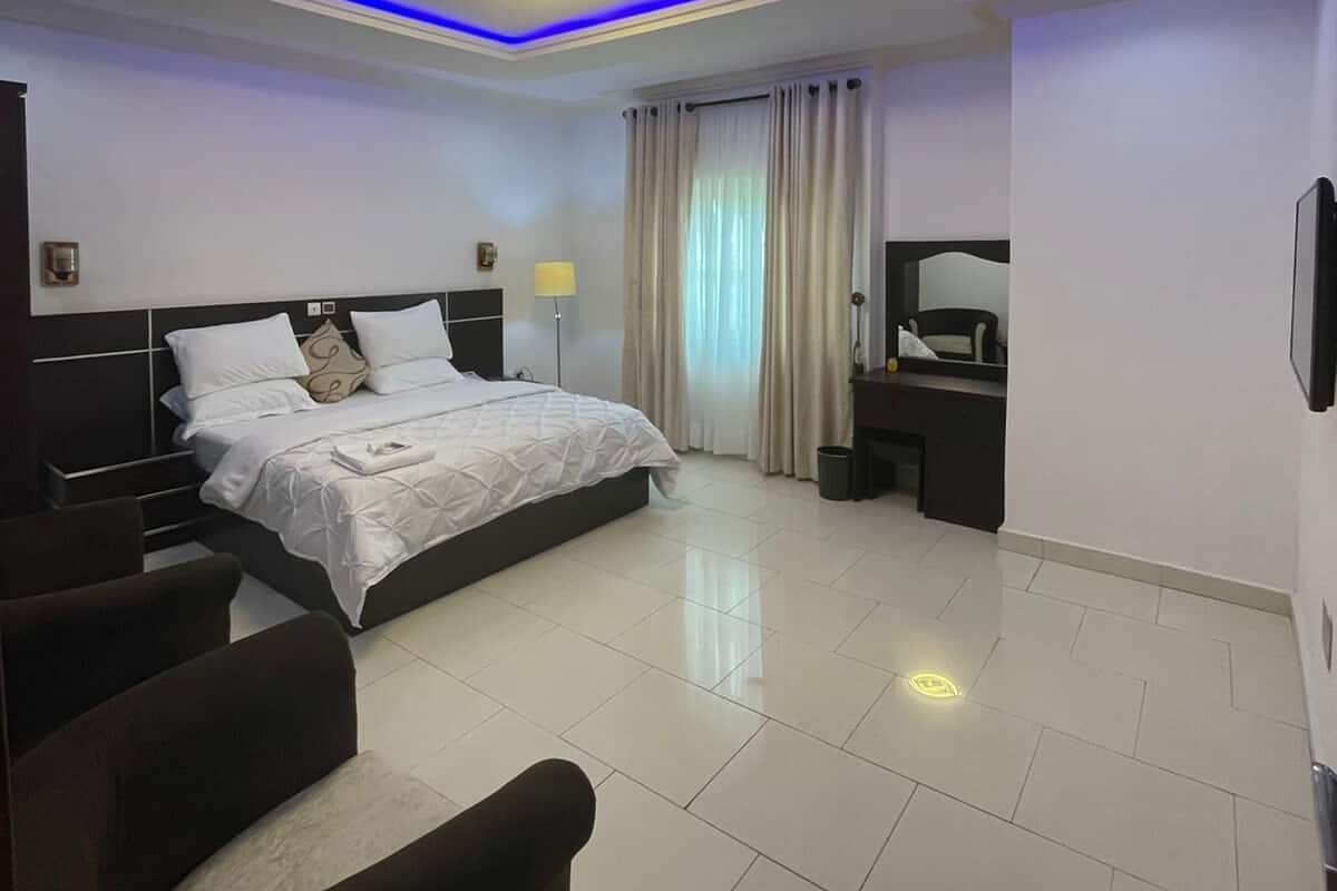 Une chambre à coucher moderne avec un lit, des tables de chevet, un bureau et une chaise.