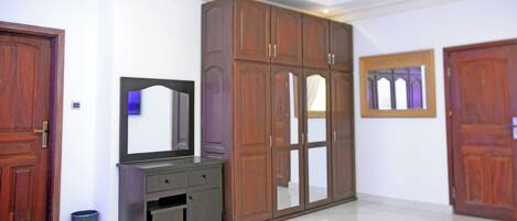 Una habitación con un armario grande, un espejo y dos puertas.